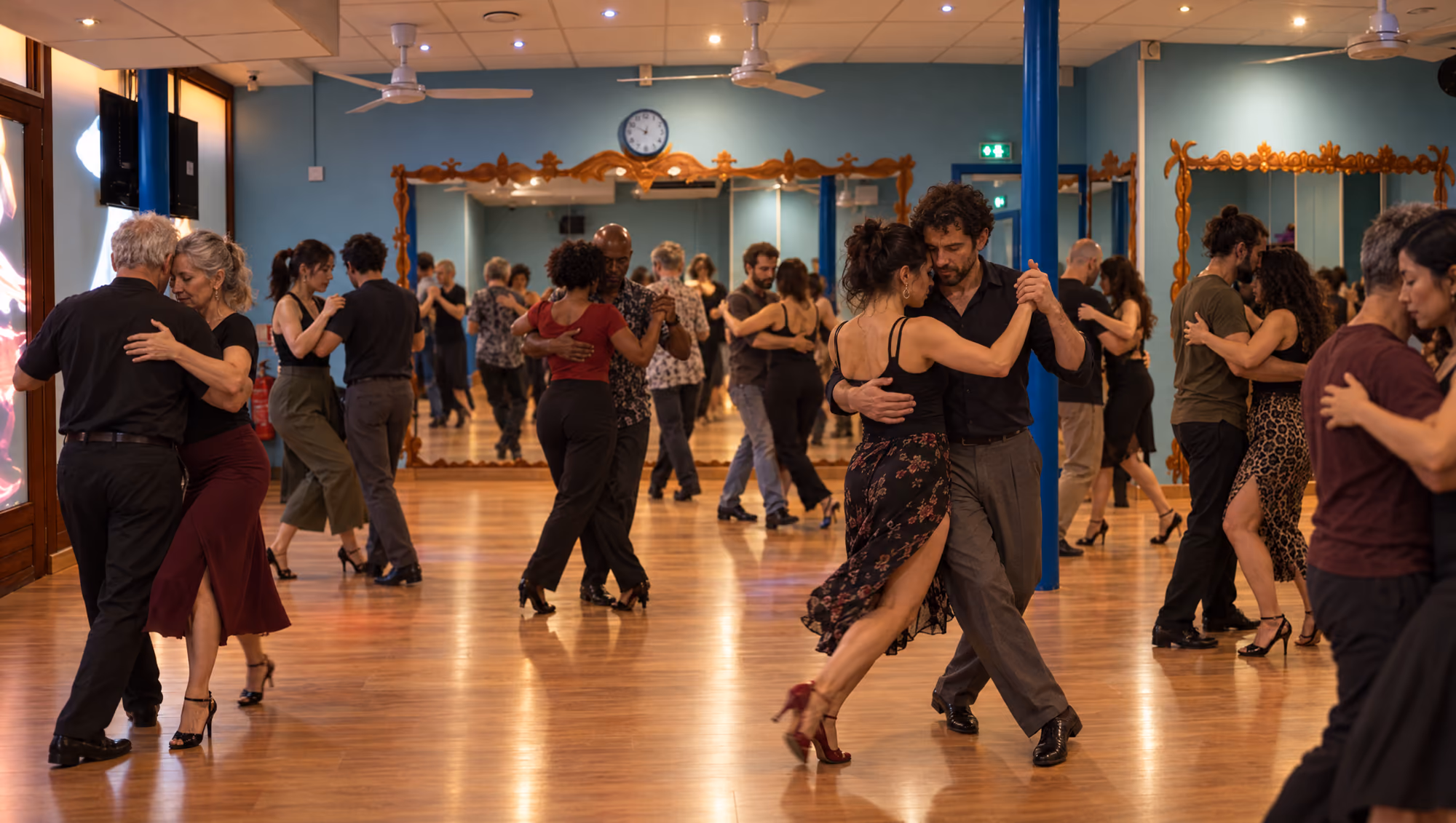 Un cours de tango argentin en pleine séance, salle bleue : une quinzaine d’élèves de tous âges et de toutes origines.