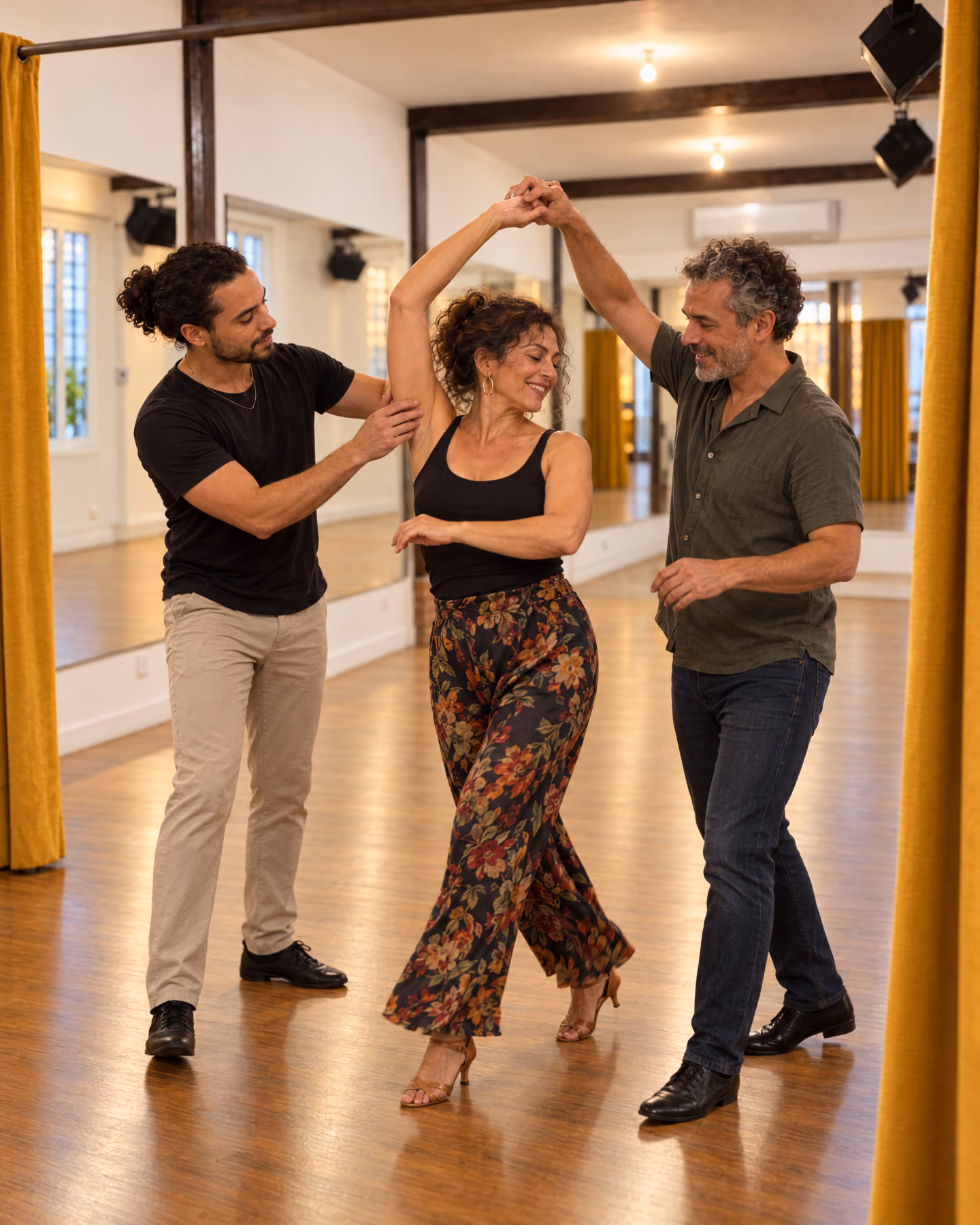 Cours particulier dans la salle safran : le professeur guide le bras de l’élève pendant qu’elle tourne sous la main de son partenaire.