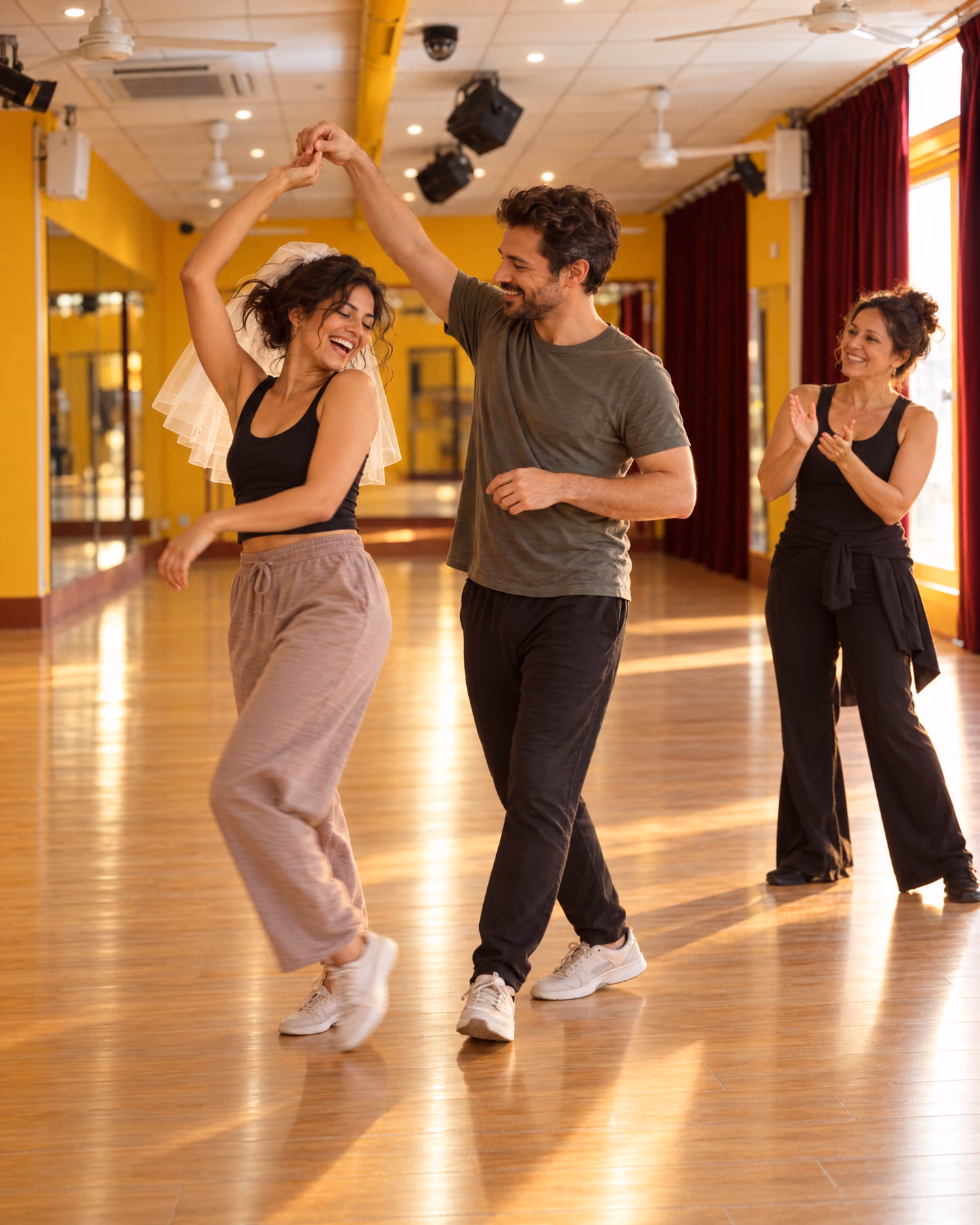 Répétition d’ouverture de bal dans la salle jaune : la future mariée, voile sur la tête, tourne en riant sous le bras de son fiancé, leur professeure bat le rythme.
